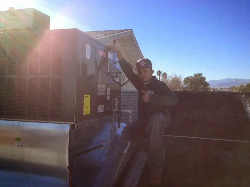 HVAC technician performing AC Tune-Up on a rooftop unit in Macon